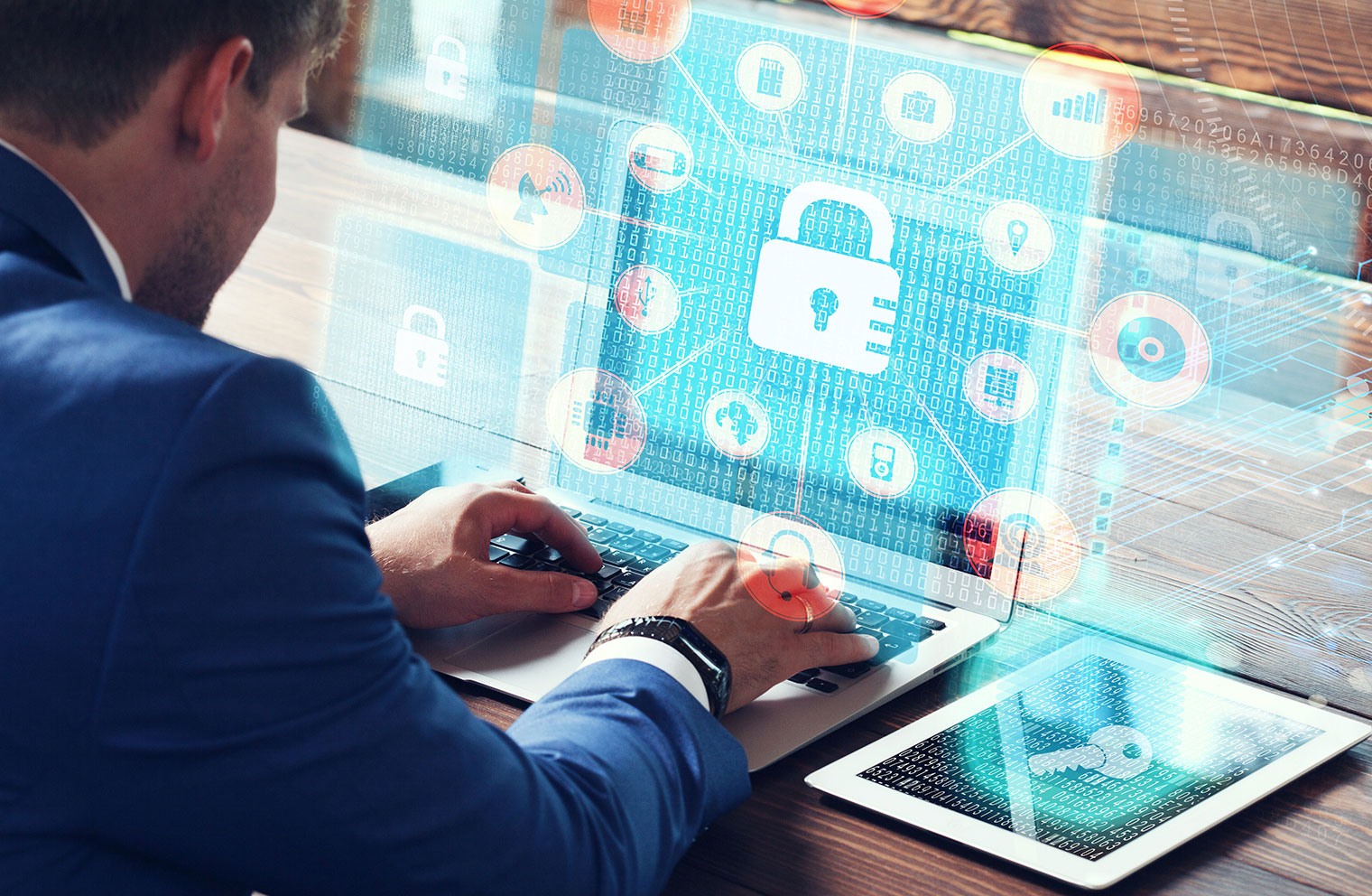 Image of padlock and security graphics overlaying image of man at desk with laptop 