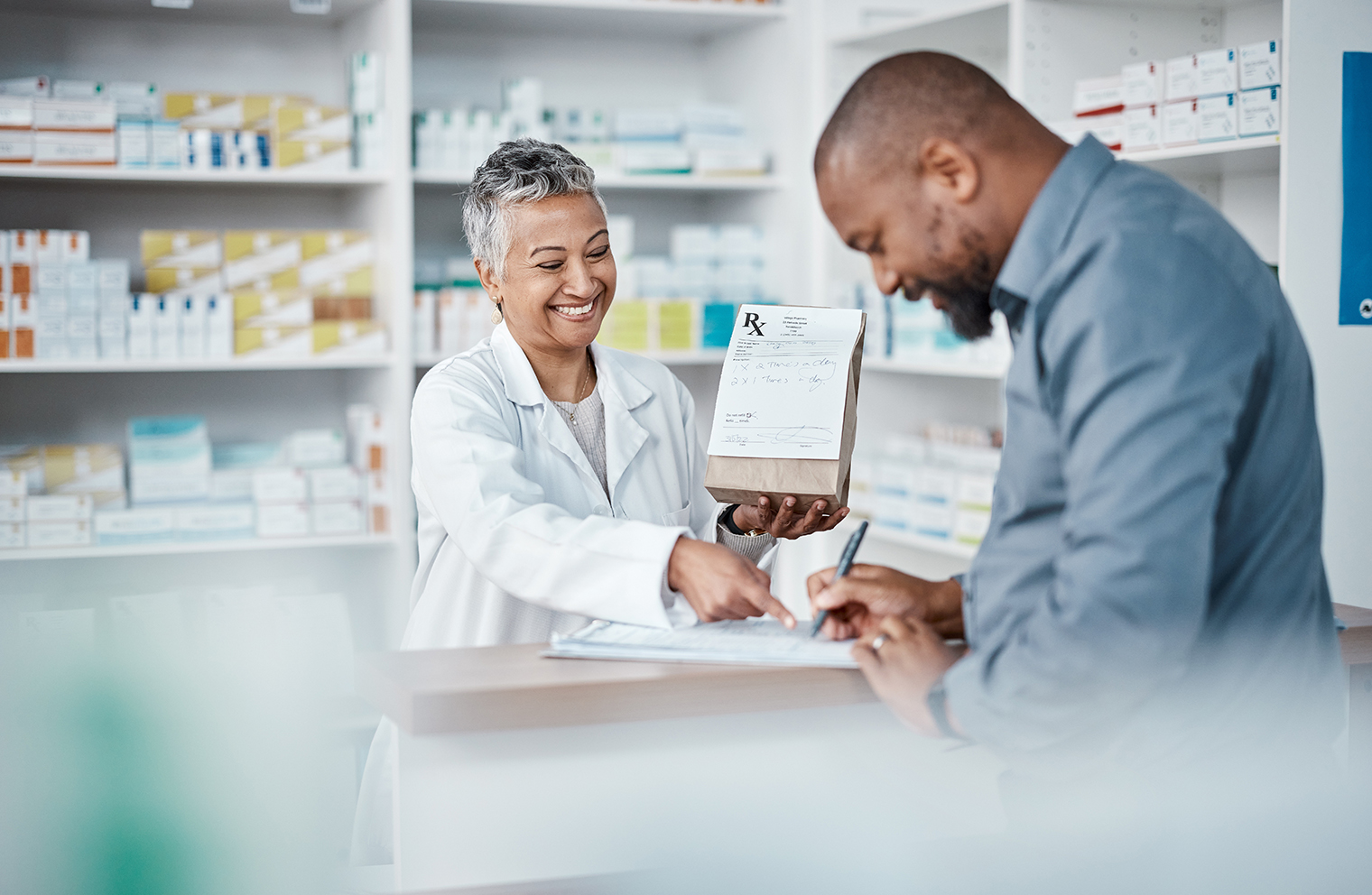 A pharmacist helps a patient save money on prescription medications. 