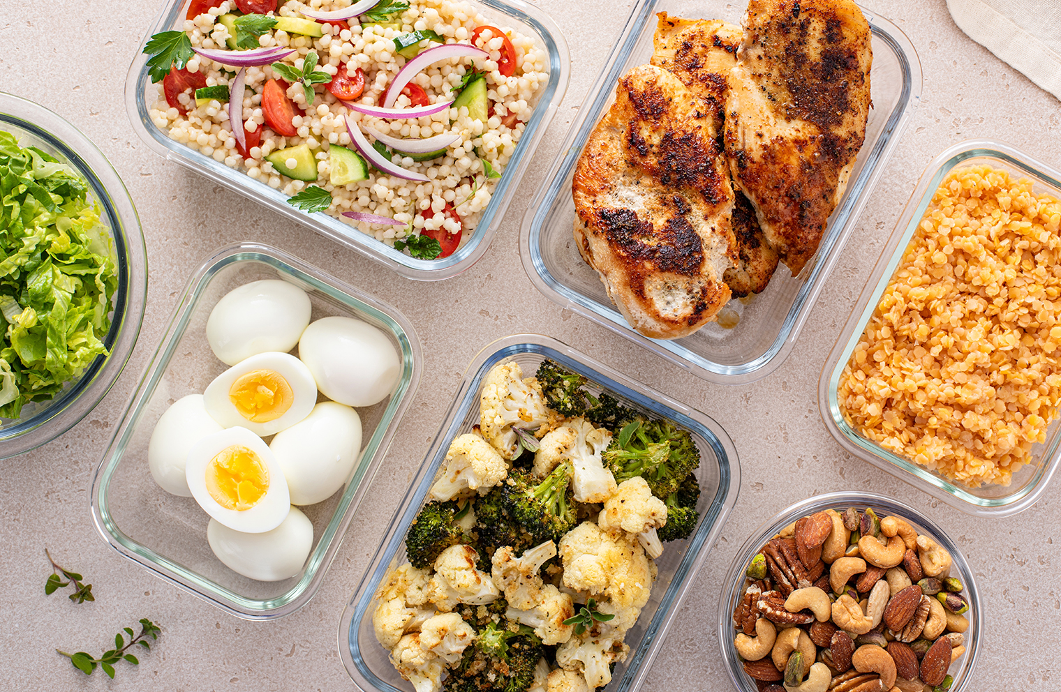 Nutritional foods including chicken breasts, vegetables, eggs and mixed nuts.