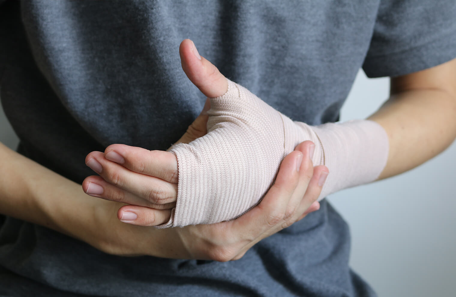 A hand and wrist are wrapped in a bandage. 