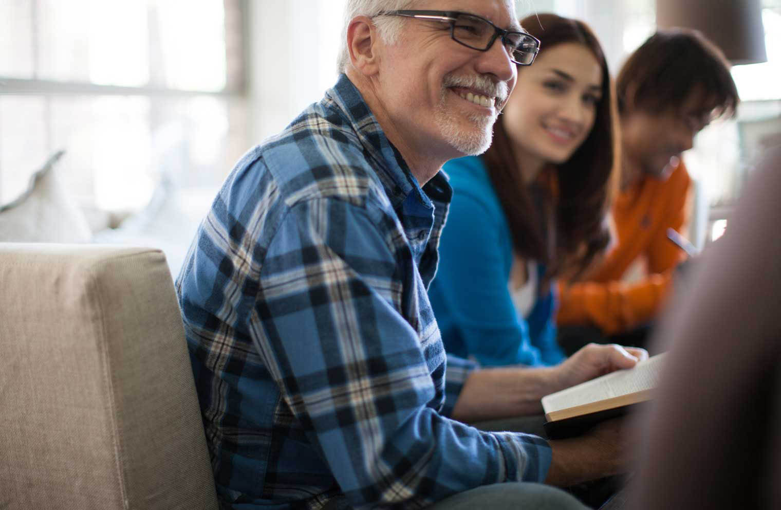 Picture of a man with glasses smiling in a meeting
