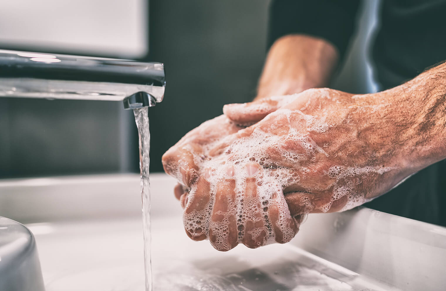 Close up picture of a man washing his hands.