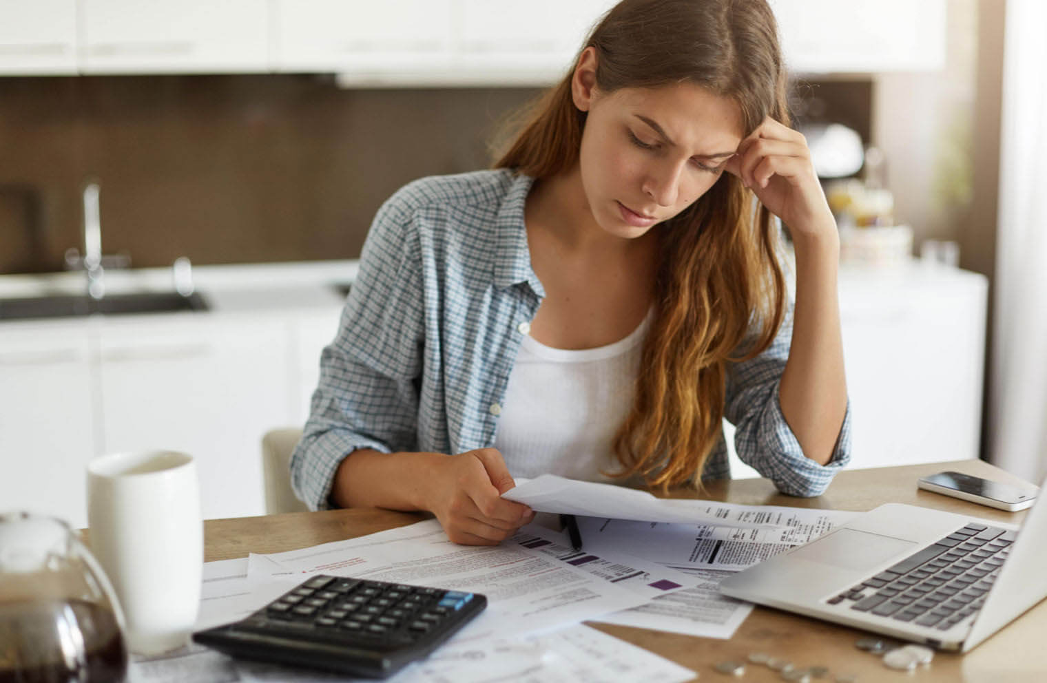 A woman appears frustrated as she looks at surprise medical bills.
