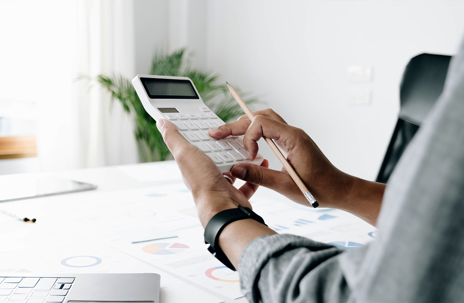 Hands using a calculator to review 2025 tax changes introduced by the One Big Beautiful Bill Act