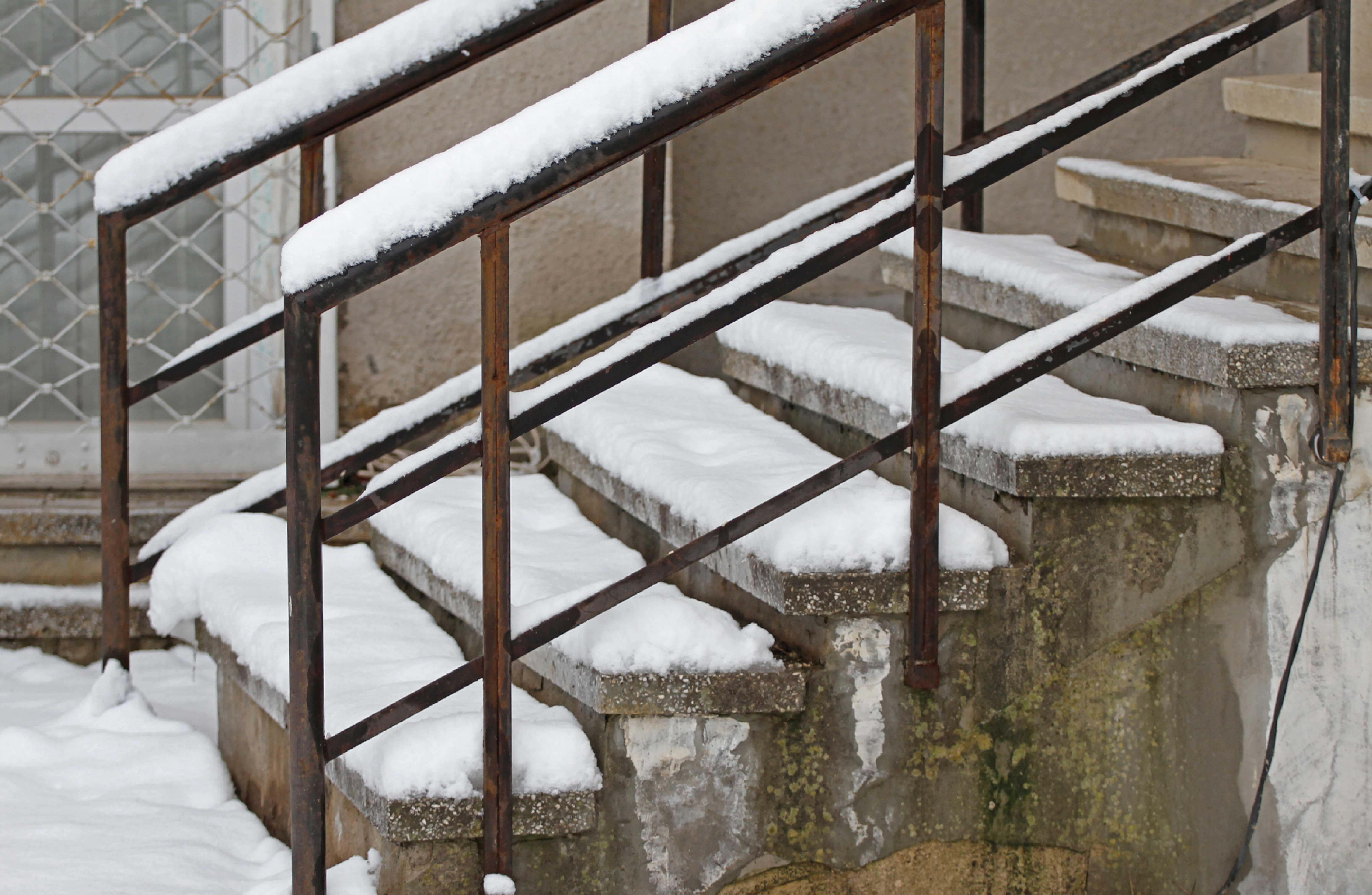 Outdoor steps and handrails are covered in snow.