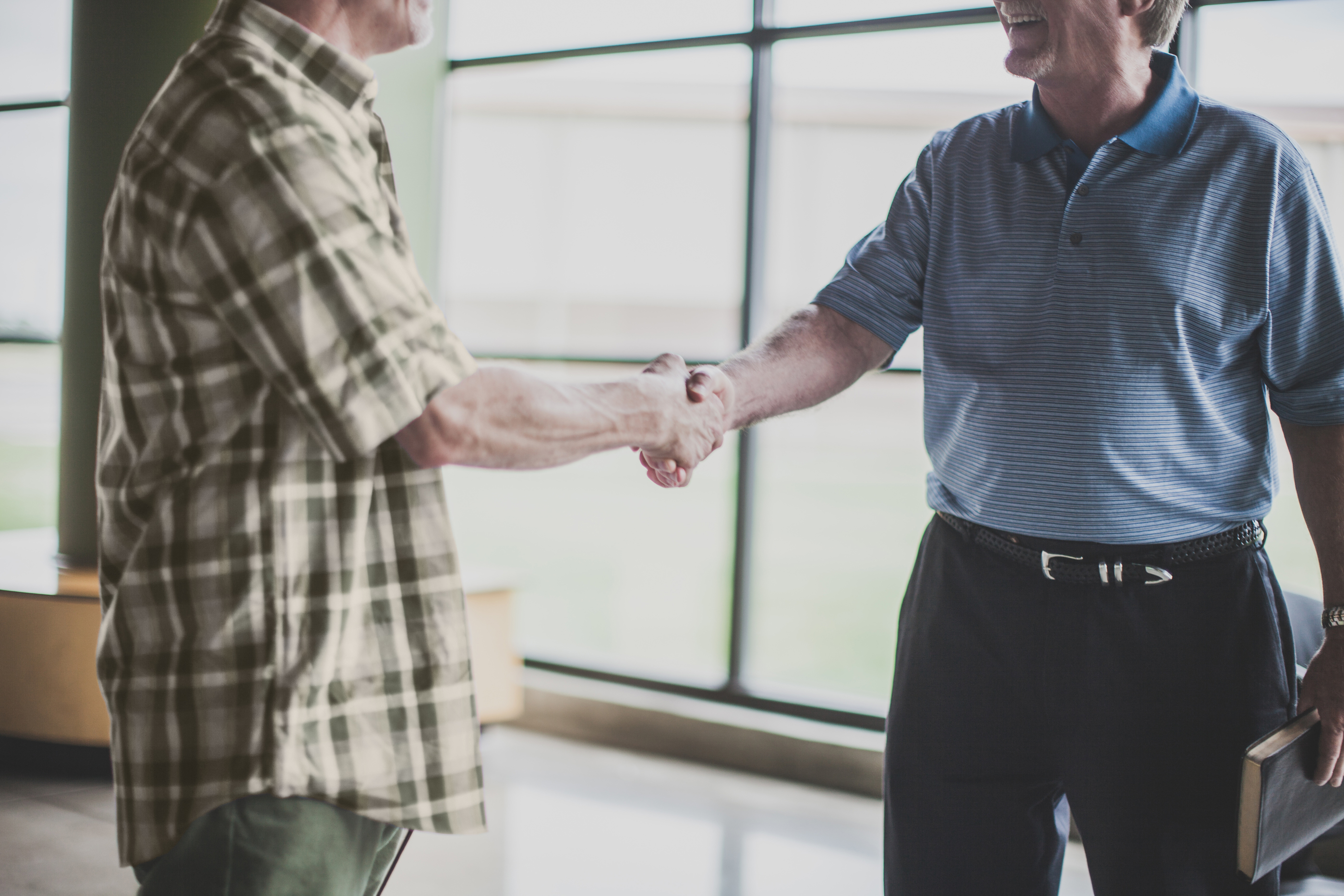 Two men shake hands at a church job interview.