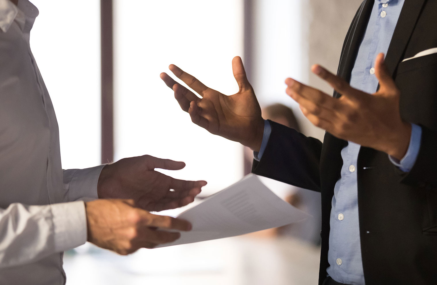 Two employees, gesturing as if working through a dispute. 