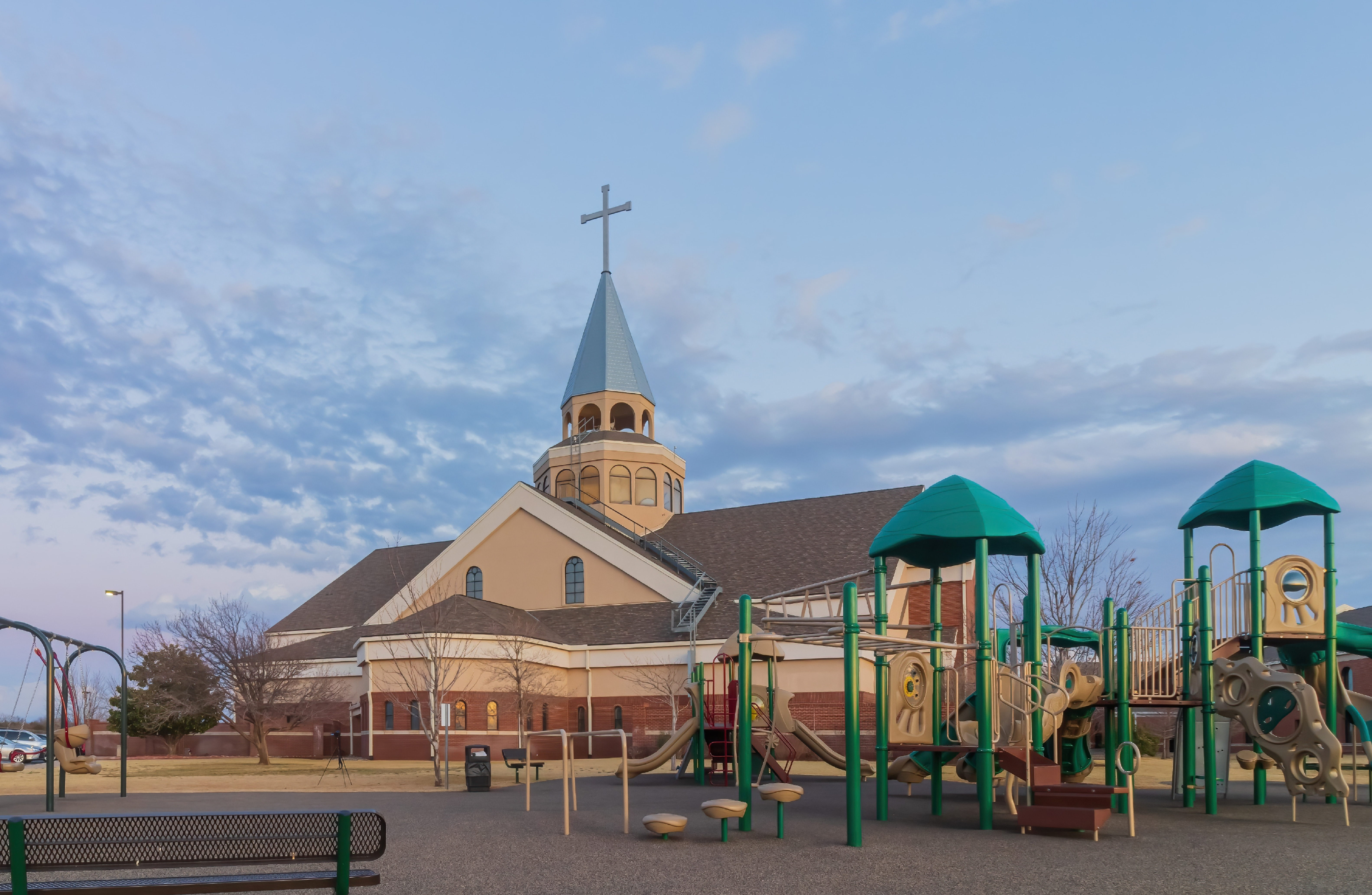 A large playground in front of a church. 