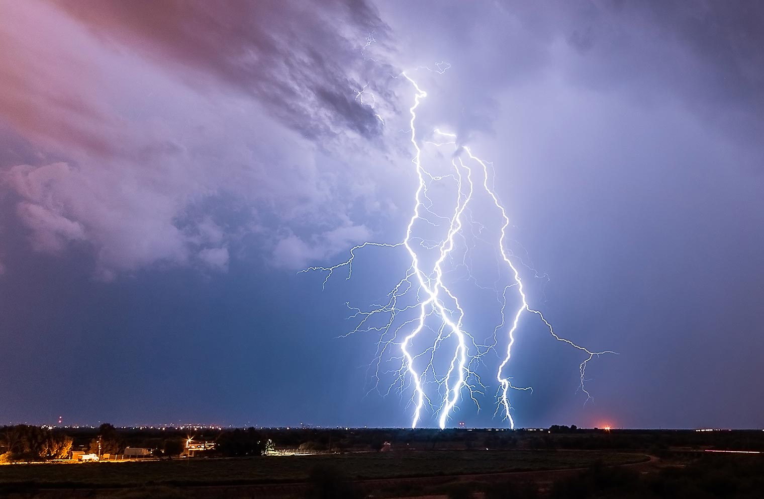 Lightning flashes across the sky. 
