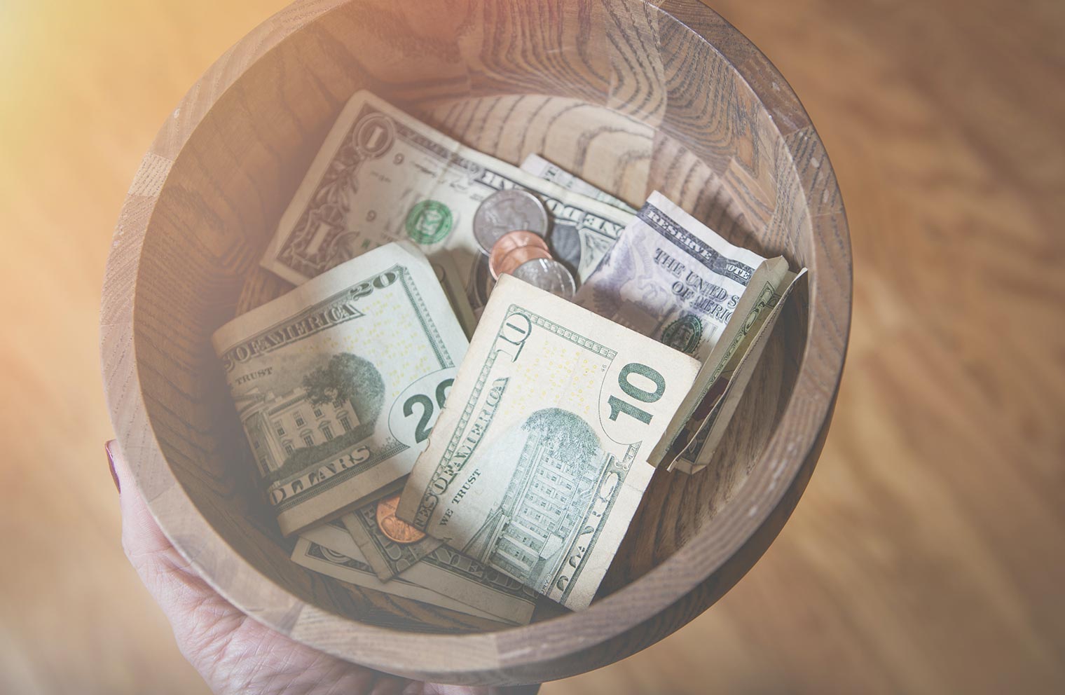 Dollars and coins in a tithing plate. 