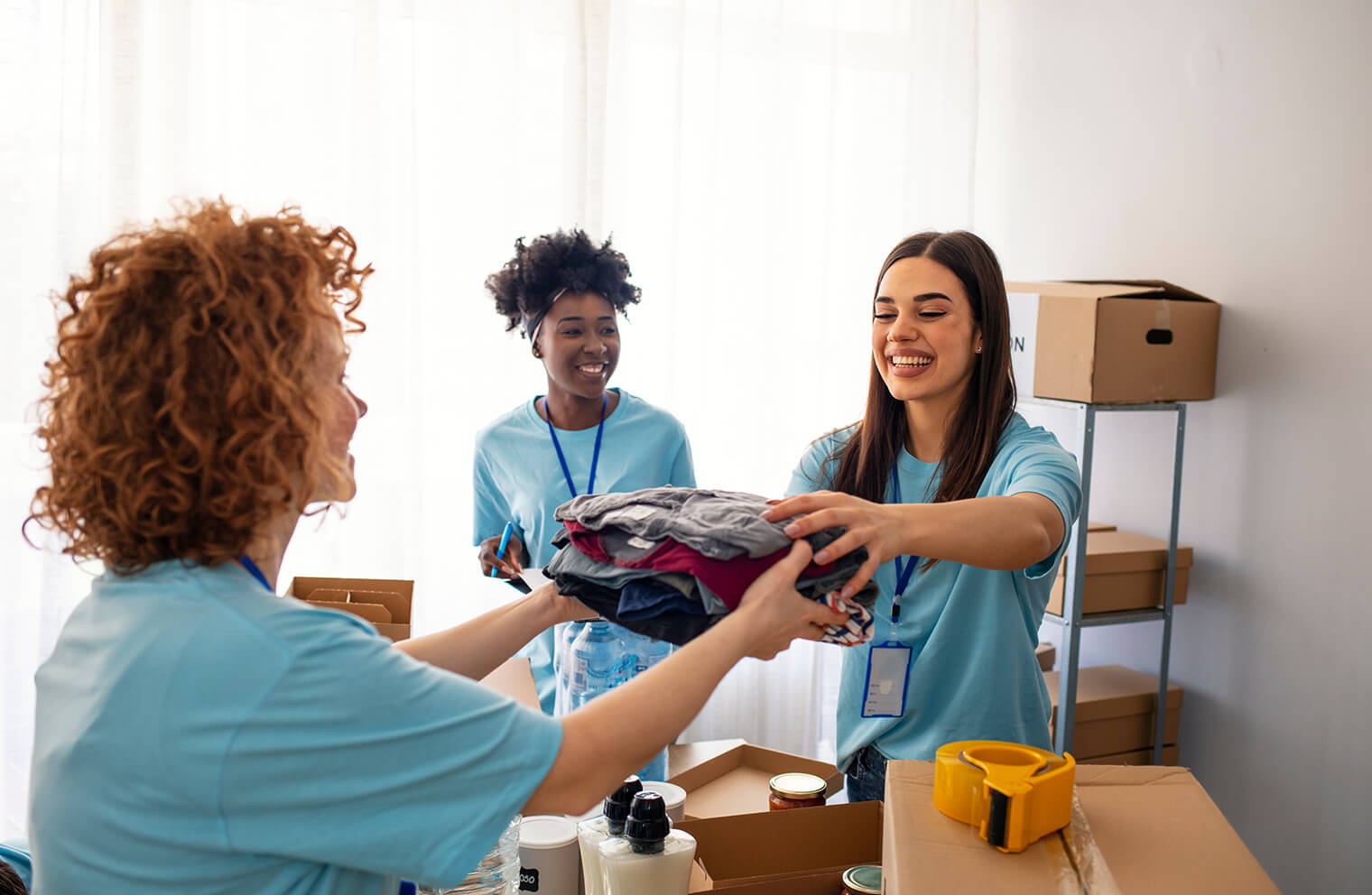 Three volunteers sort donated clothing. 