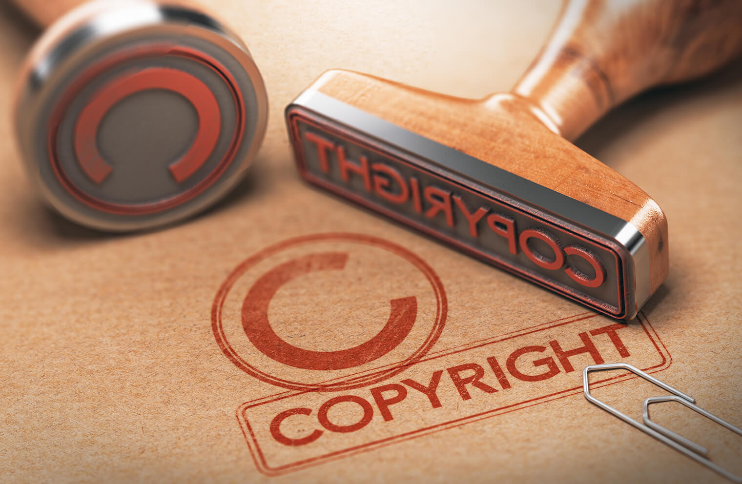 Picture of red copyright stamps on a brown folder with a metal paperclip.