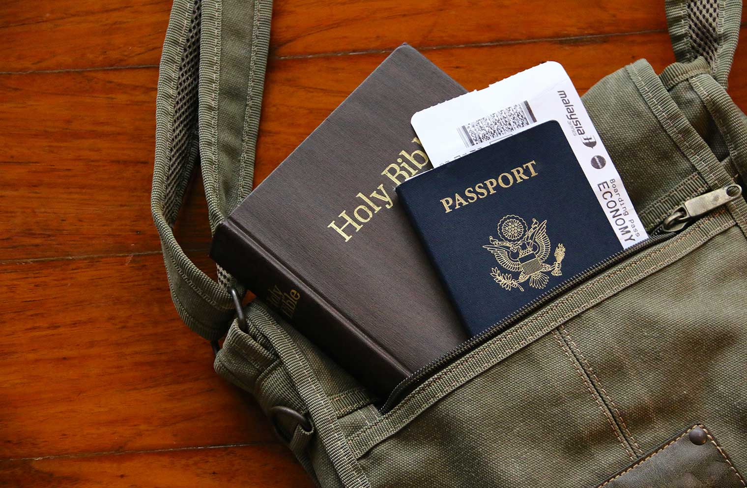 Bible, plane ticket, and passport in a travel bag